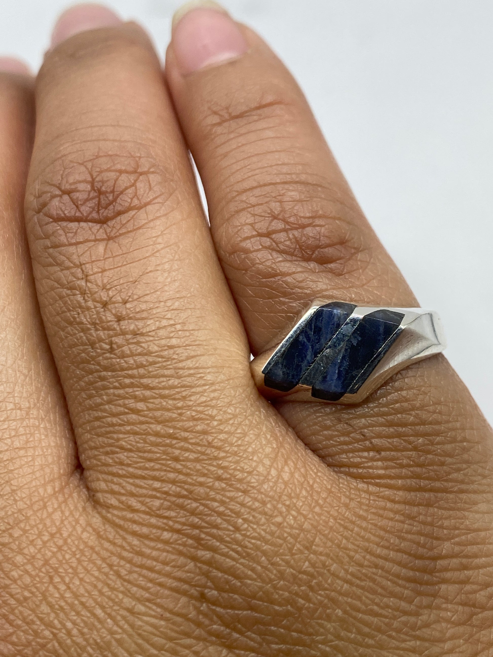 Anillo sobre fondo gris mostrando sello 925 MEXICO y el color azul profundo de la piedra