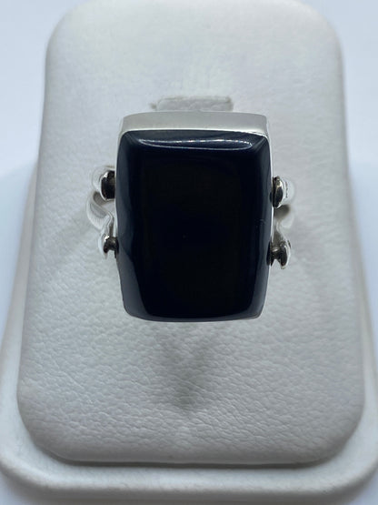 Anillo de plata con ónix negro rectangular en la mano de una mujer adulta