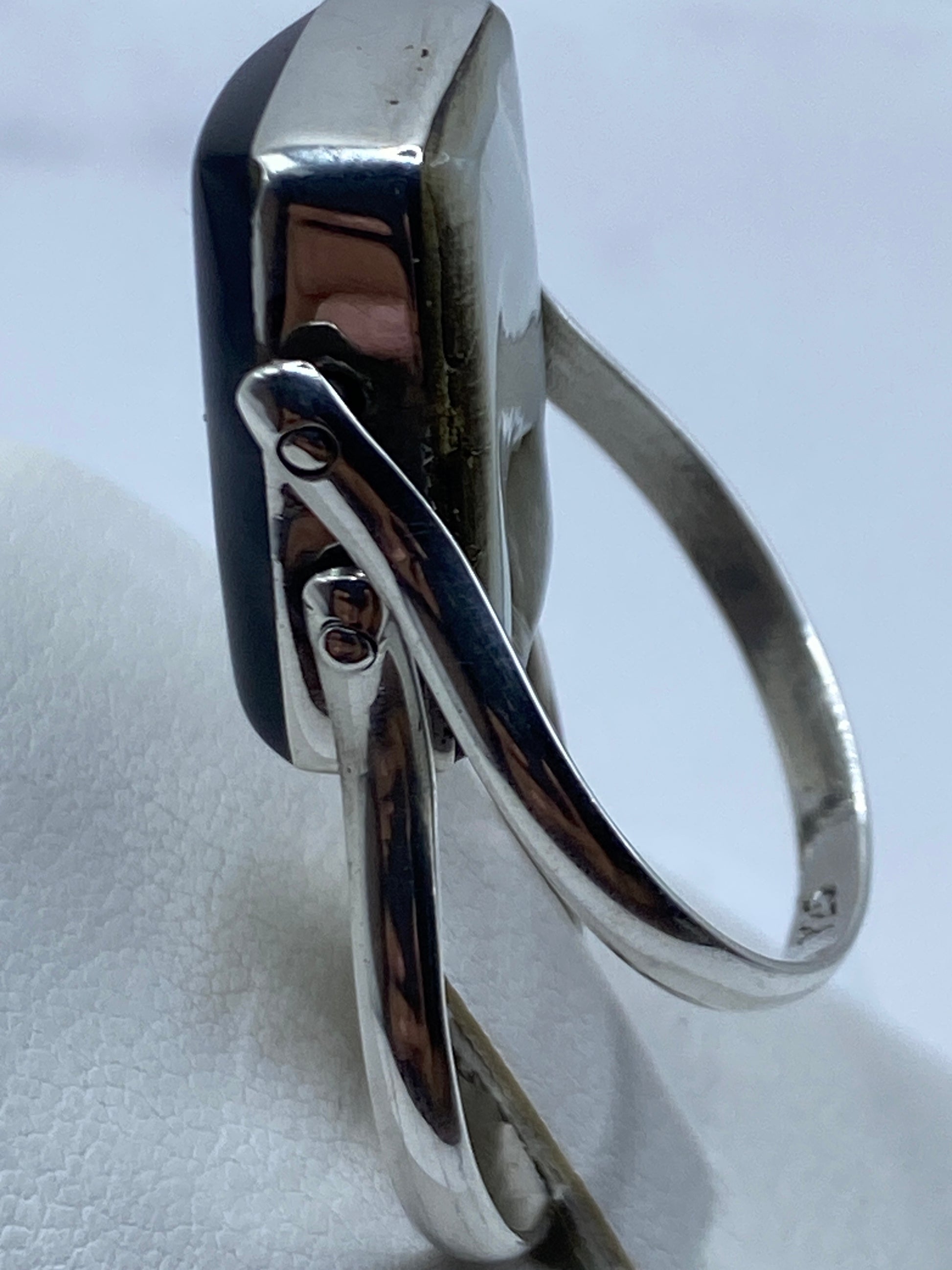 Detalle lateral del anillo mostrando los herrajes de plata que abrazan la piedra