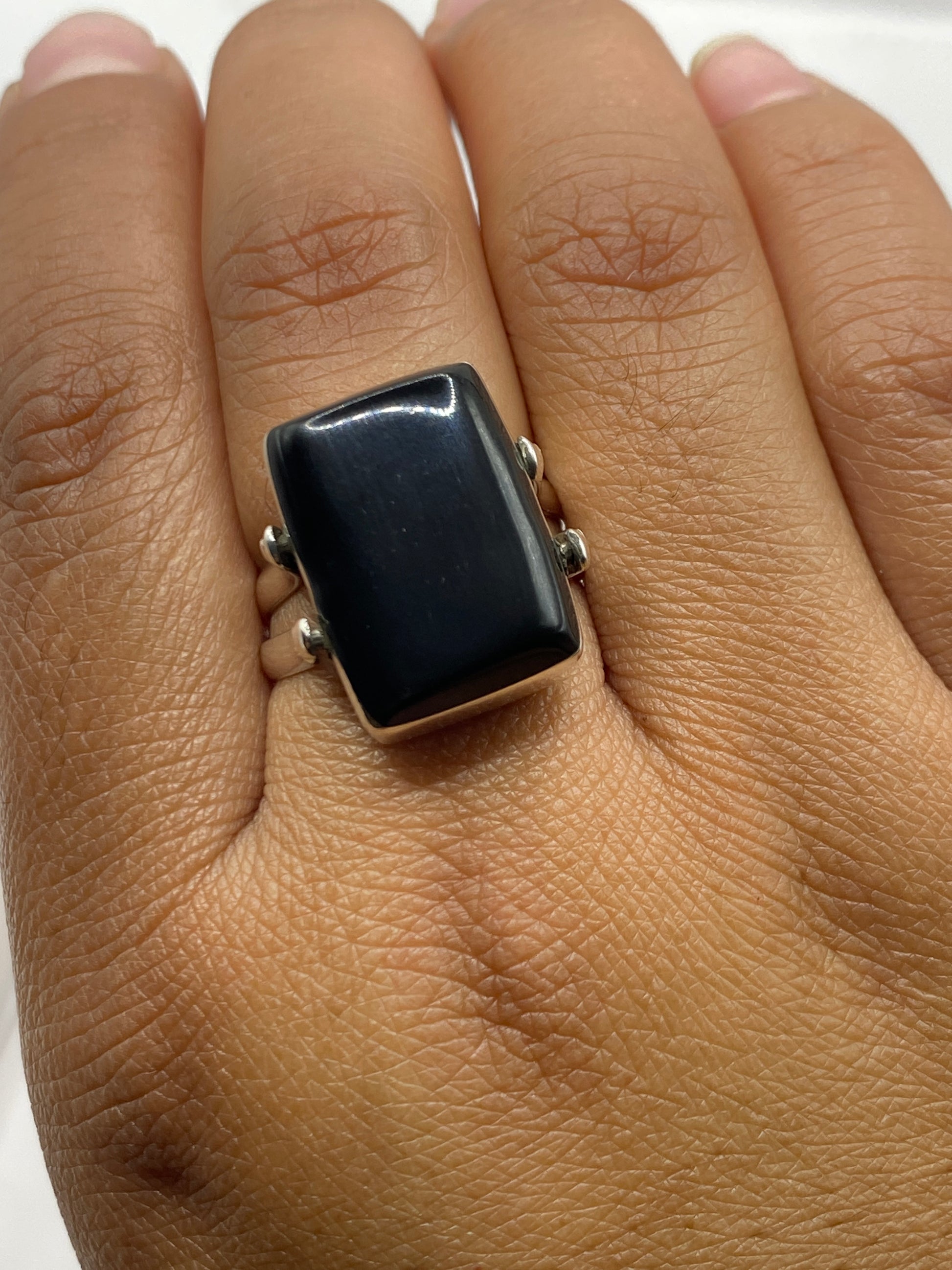 Anillo de ónix y plata sobre fondo blanco con sello 925 visible en la banda