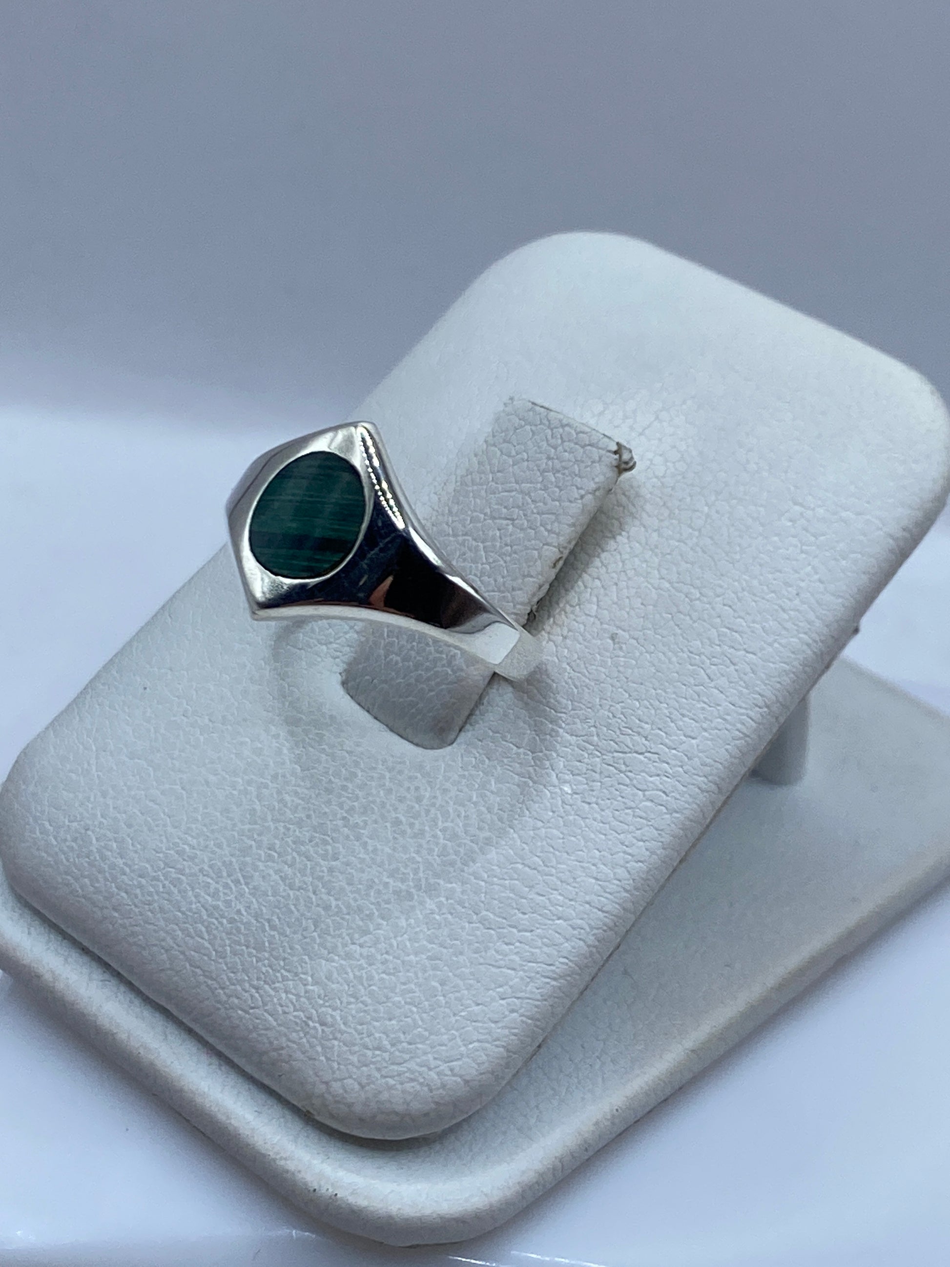 Anillo solitario malaquita en mano de mujer, mostrando vetas naturales verdes