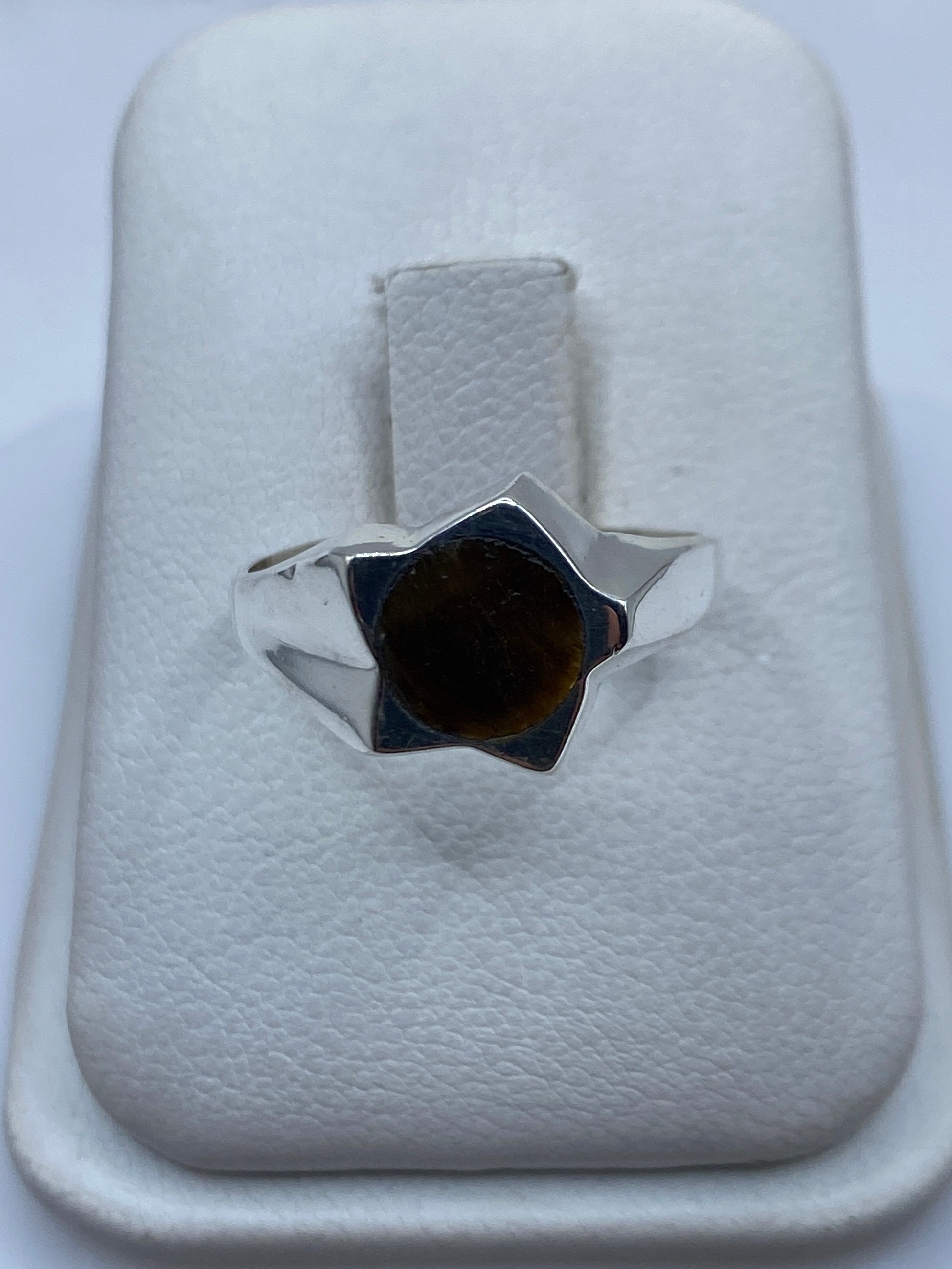 Anillo de plata solitario con piedra café en tonalidad cálida sobre estuche blanco