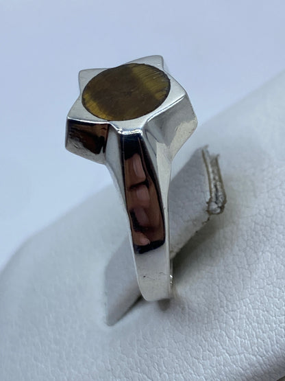 Detalle del frente del anillo con piedra café natural iluminada