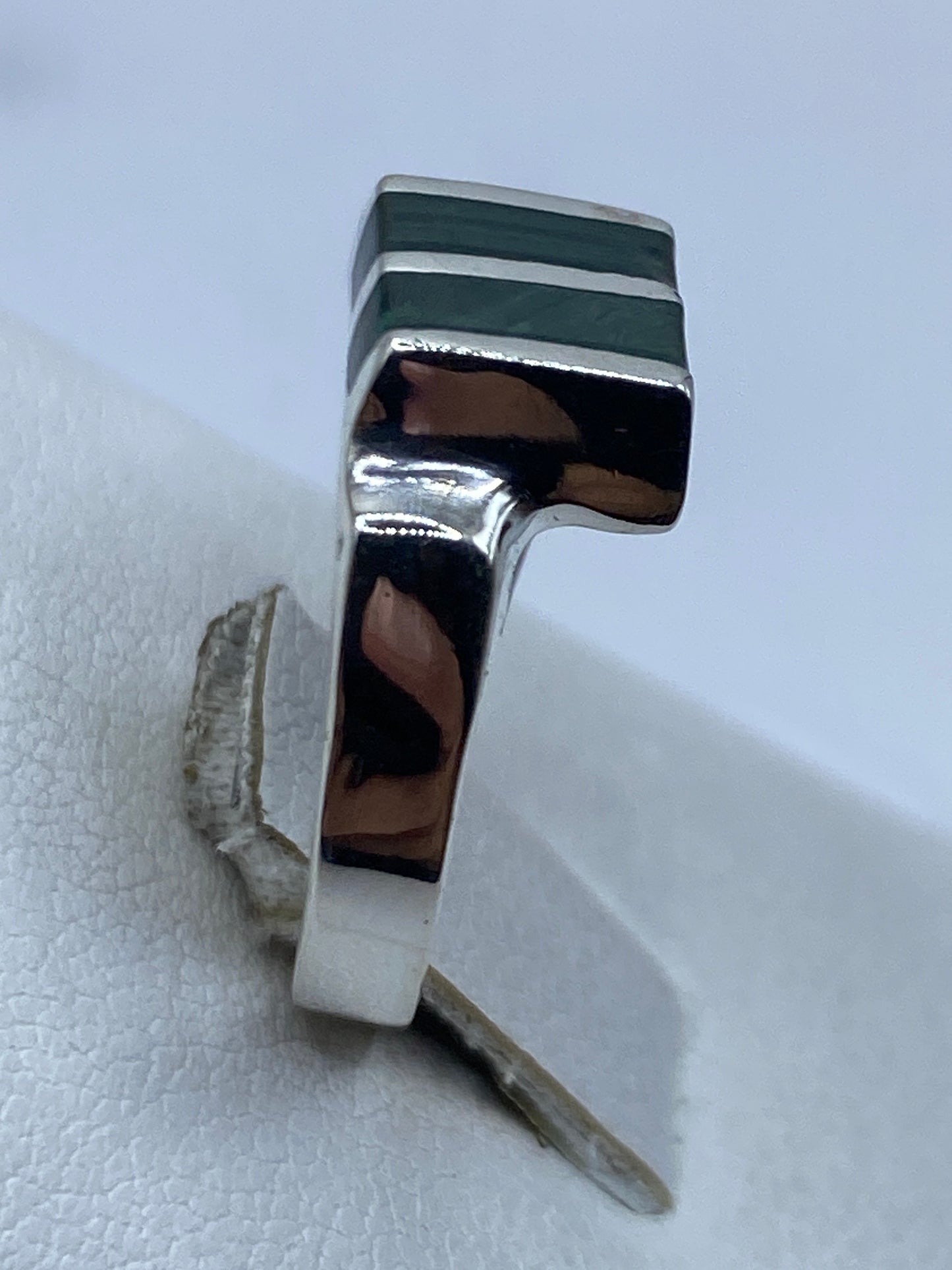 Detalle de la malaquita verde con vetas negras engastada en plata