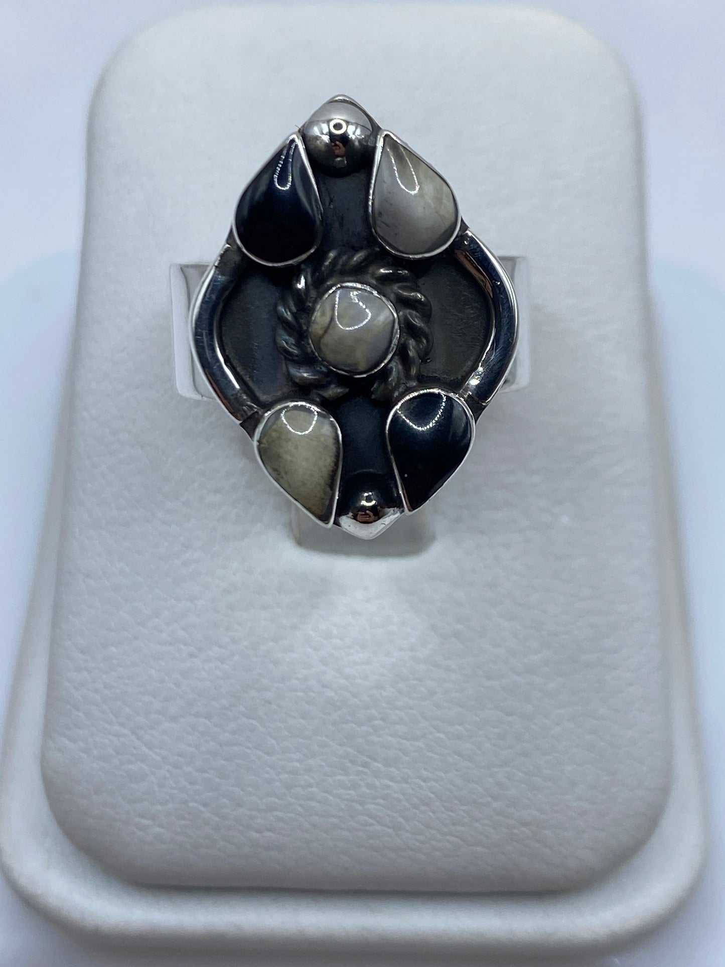 Anillo de plata con ónix negro pulido en engastes geométricos, visto de frente