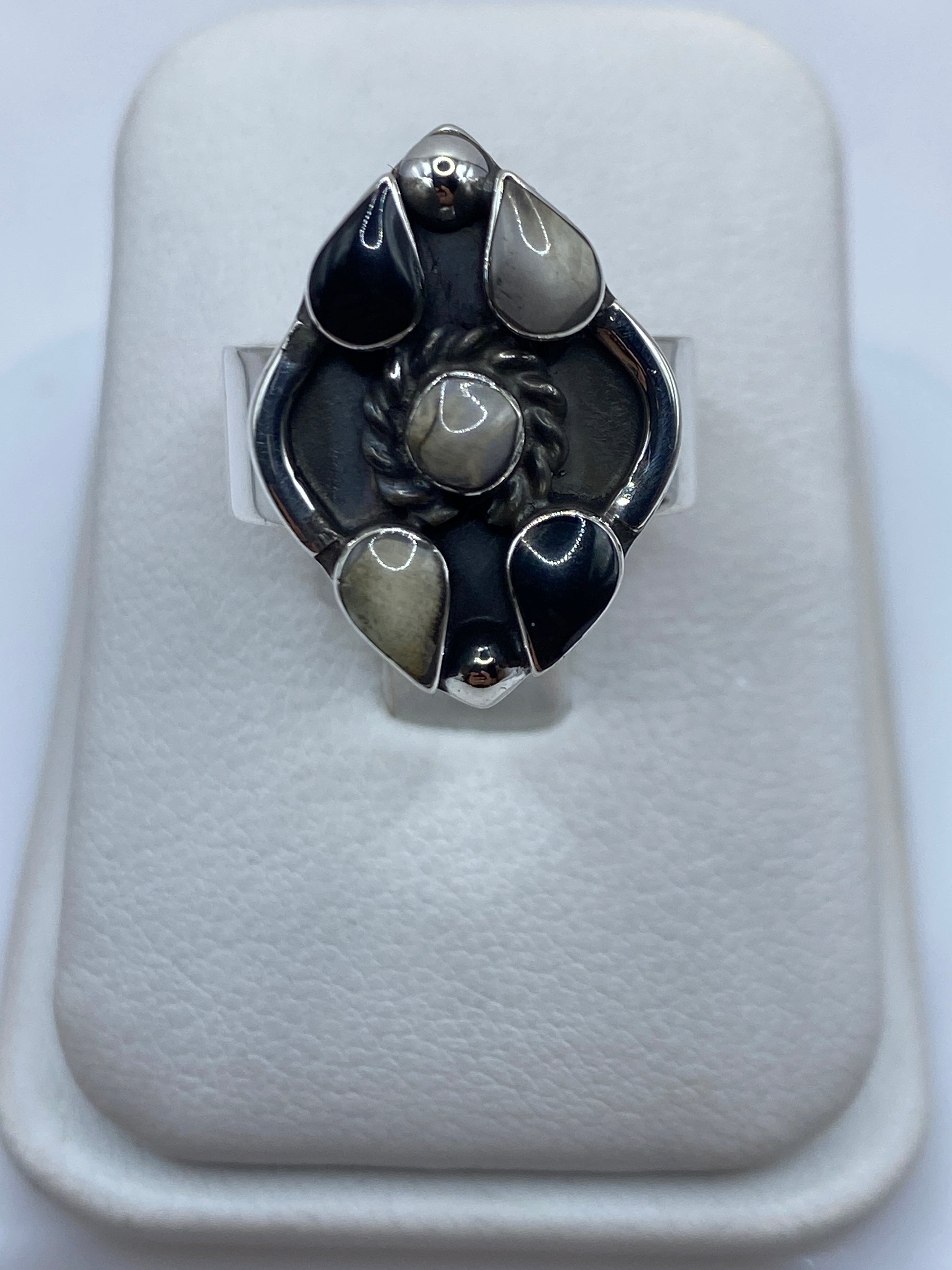 Anillo de plata con ónix negro pulido en engastes geométricos, visto de frente
