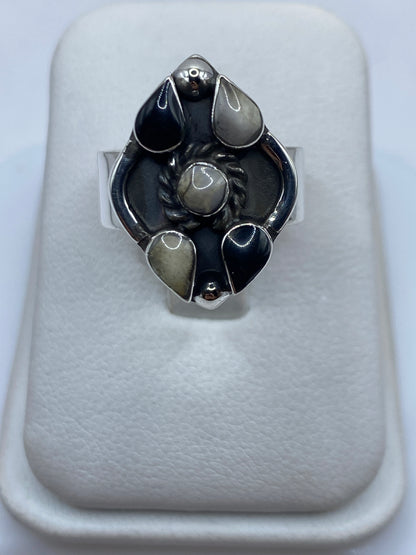 Anillo de plata con ónix negro pulido en engastes geométricos, visto de frente