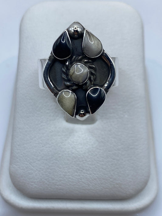 Anillo de plata con ónix negro pulido en engastes geométricos, visto de frente