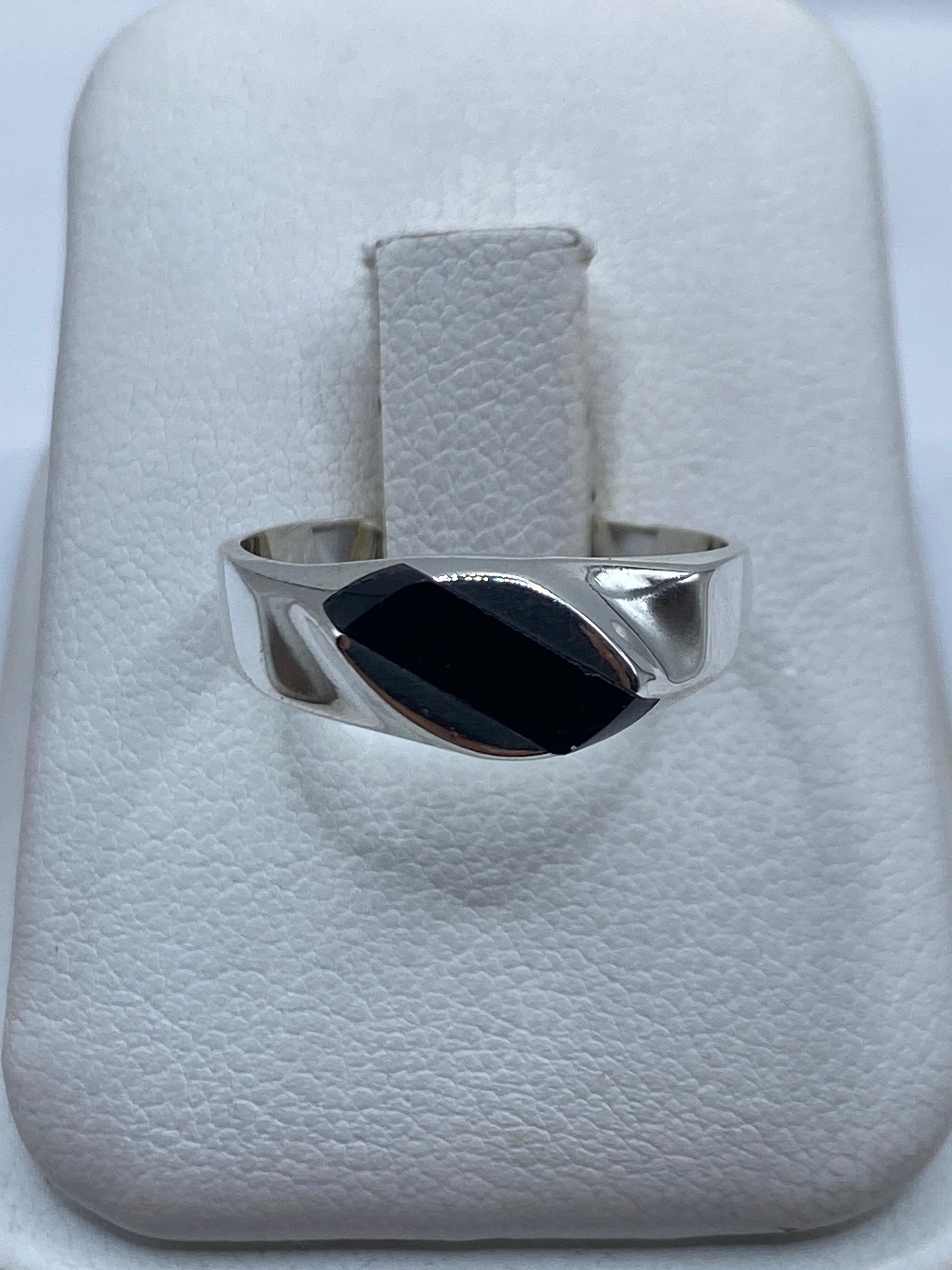 Anillo de plata con ónix negro en estuche blanco, vista frontal del engaste