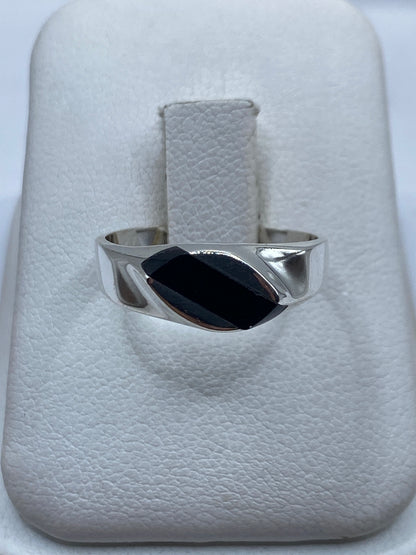 Anillo de plata con ónix negro en estuche blanco, vista frontal del engaste