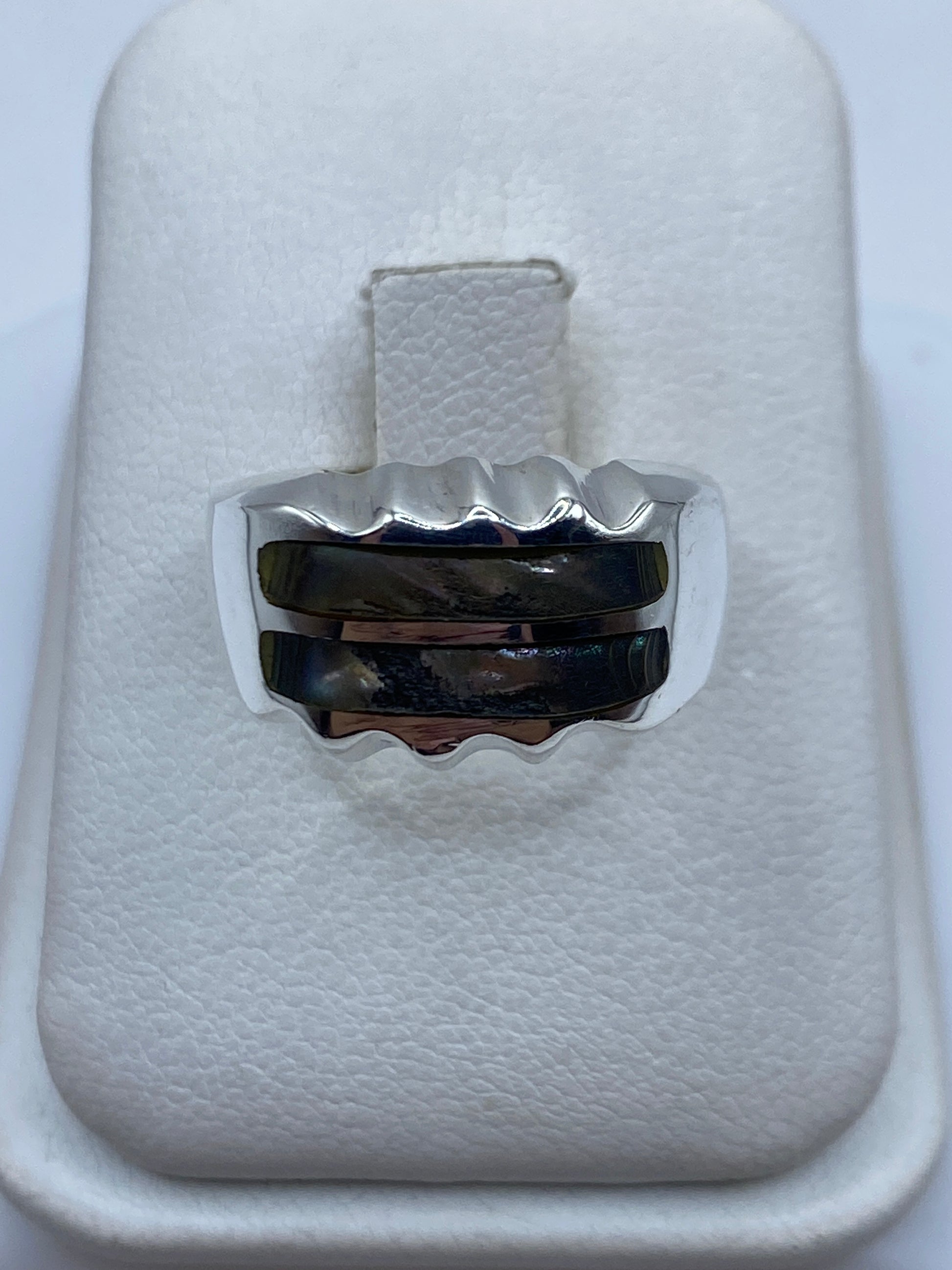 Anillo de plata onda minimalista con piedra incrustada en mano de hombre