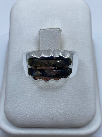 Anillo de plata onda minimalista con piedra incrustada en mano de hombre
