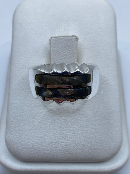 Anillo de plata onda minimalista con piedra incrustada en mano de hombre