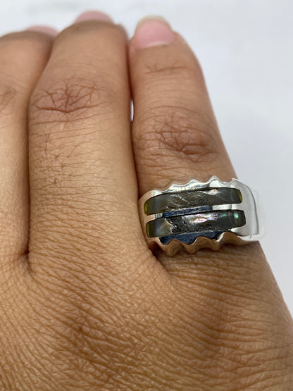 Anillo minimalista sobre fondo gris mostrando el diseño fluido y la incrustación de piedra