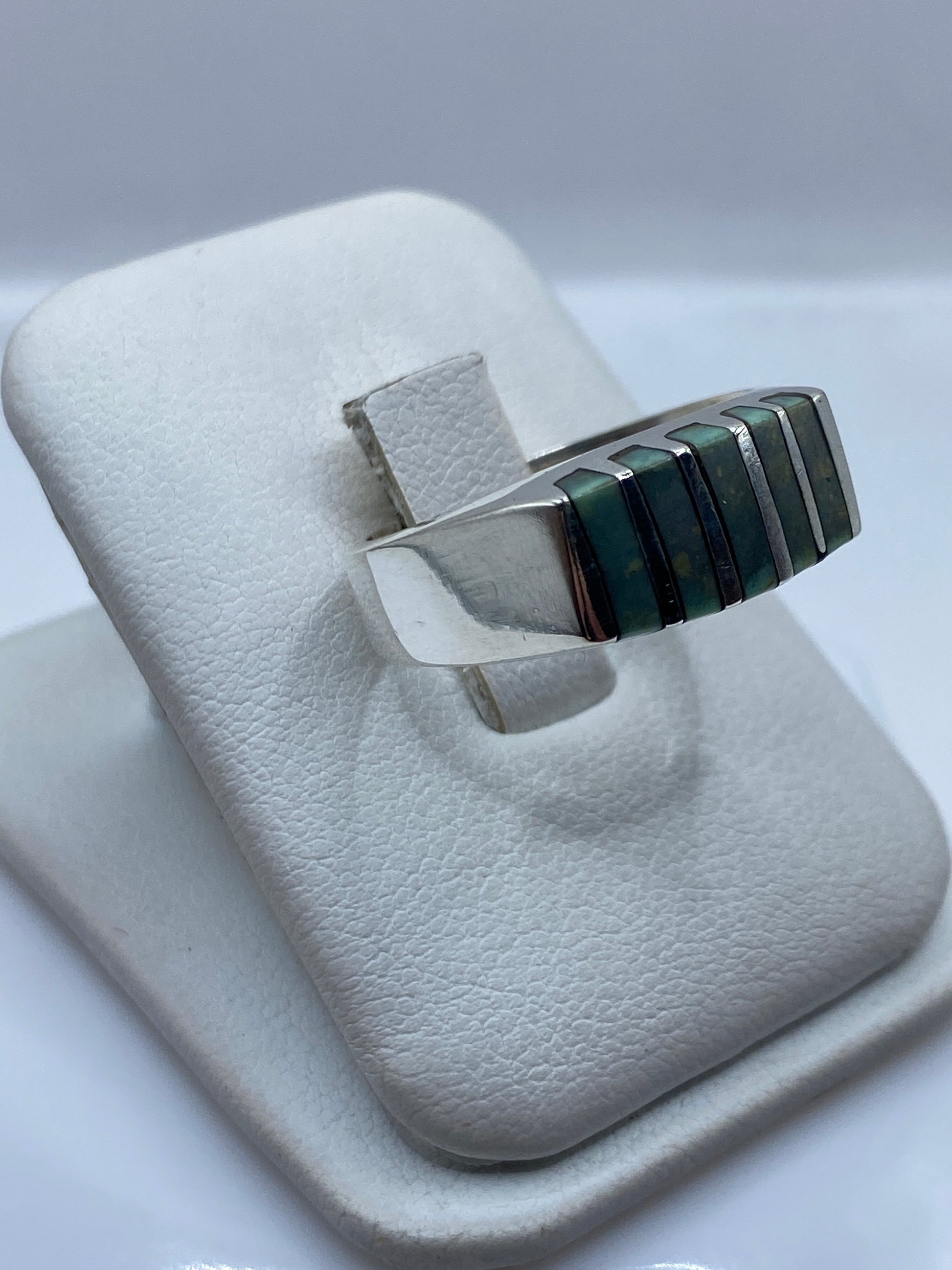 Anillo eslabón arquitectónico de plata en la mano, mostrando peso y presencia