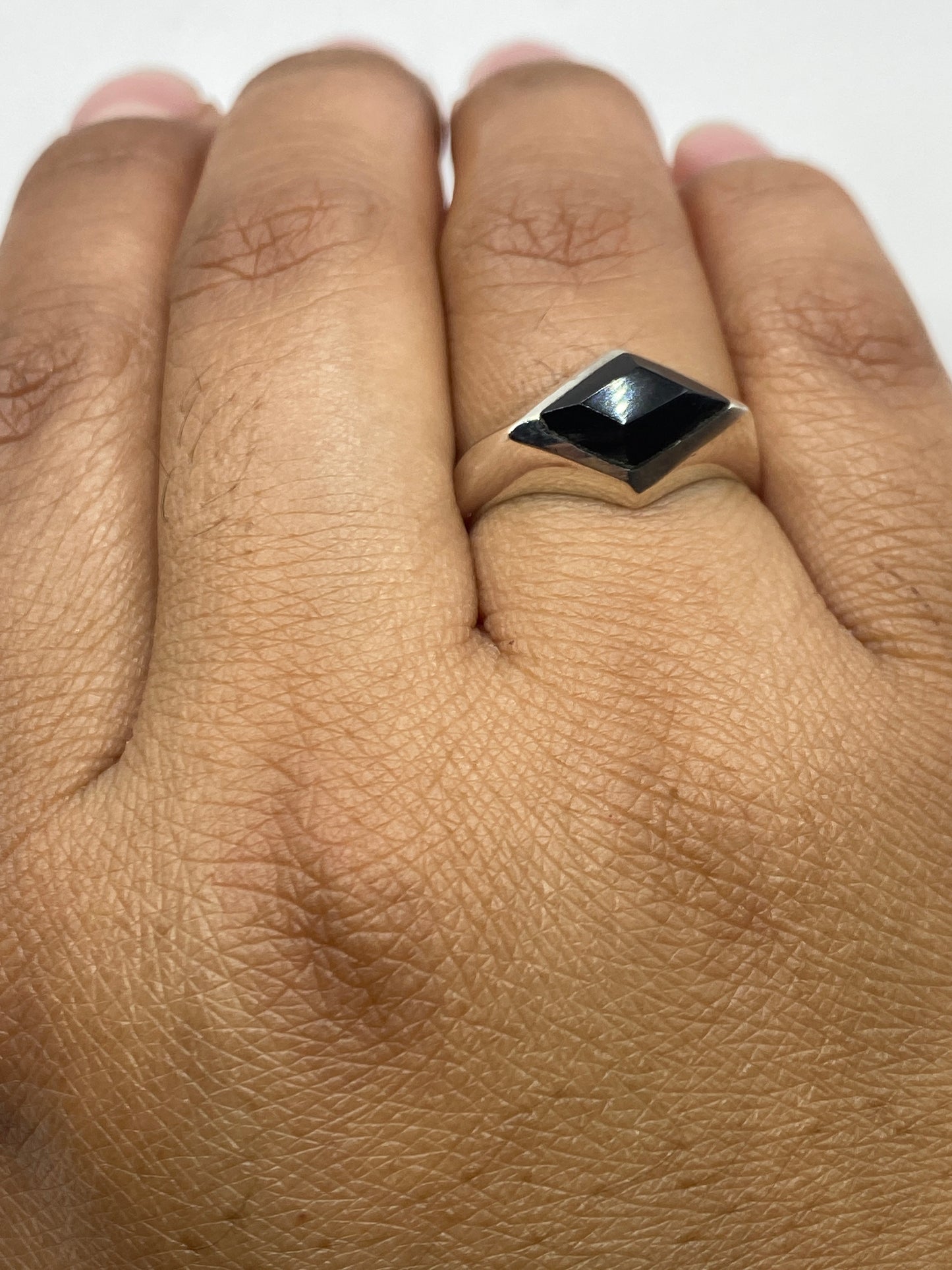 Anillo ónix en dedo de hombre mostrando diseño minimalista y proporciones