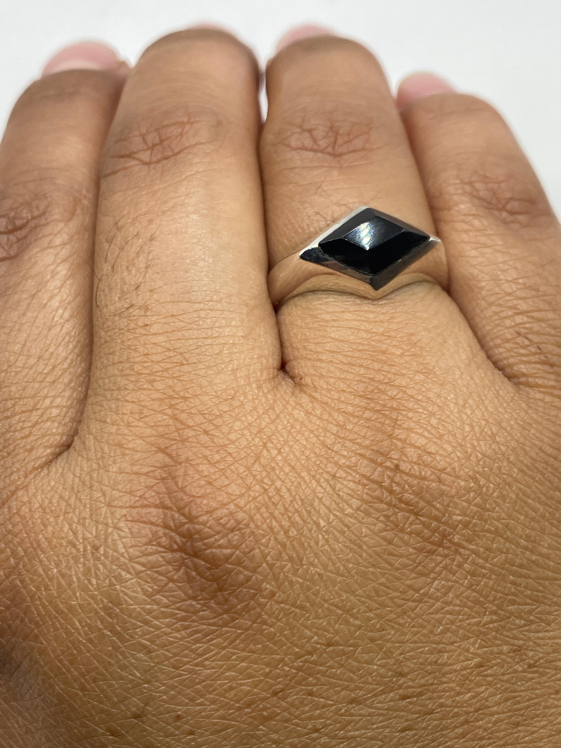 Anillo ónix en dedo de hombre mostrando diseño minimalista y proporciones
