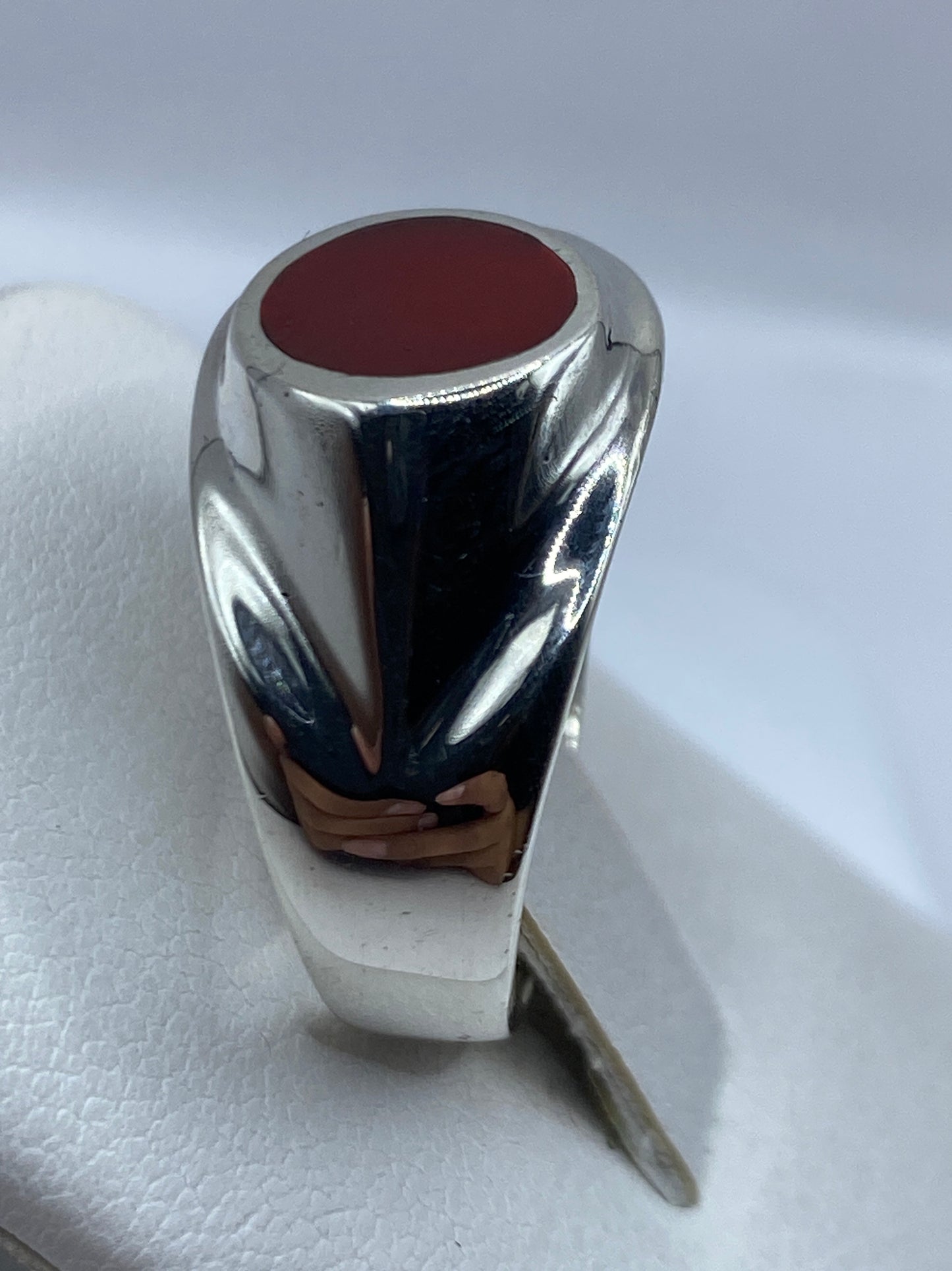 Anillo masculino de plata y coral sobre fondo blanco mostrando el sello 925