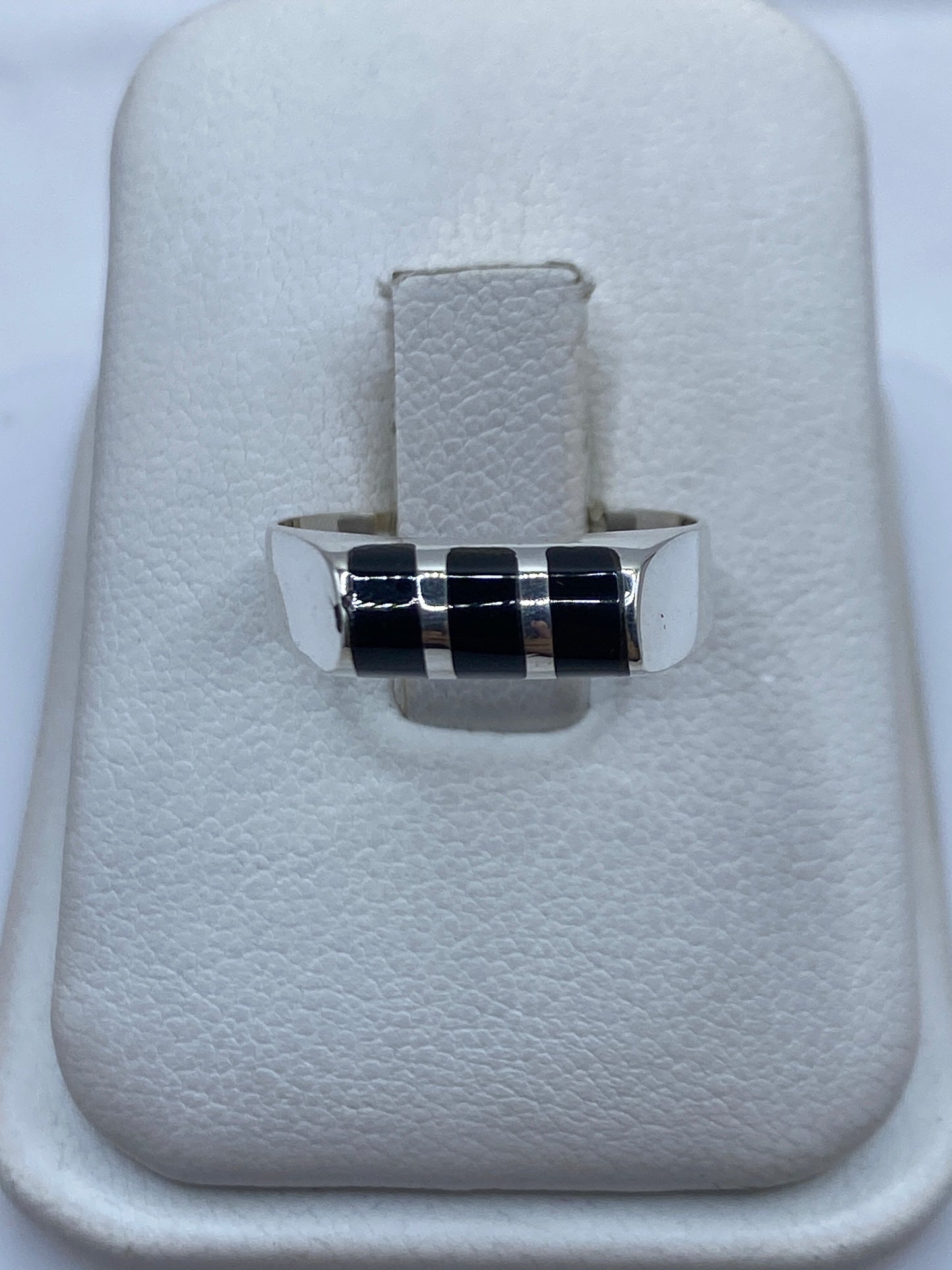 Anillo de plata .925 con ónix negro solitario visto de frente sobre estuche blanco