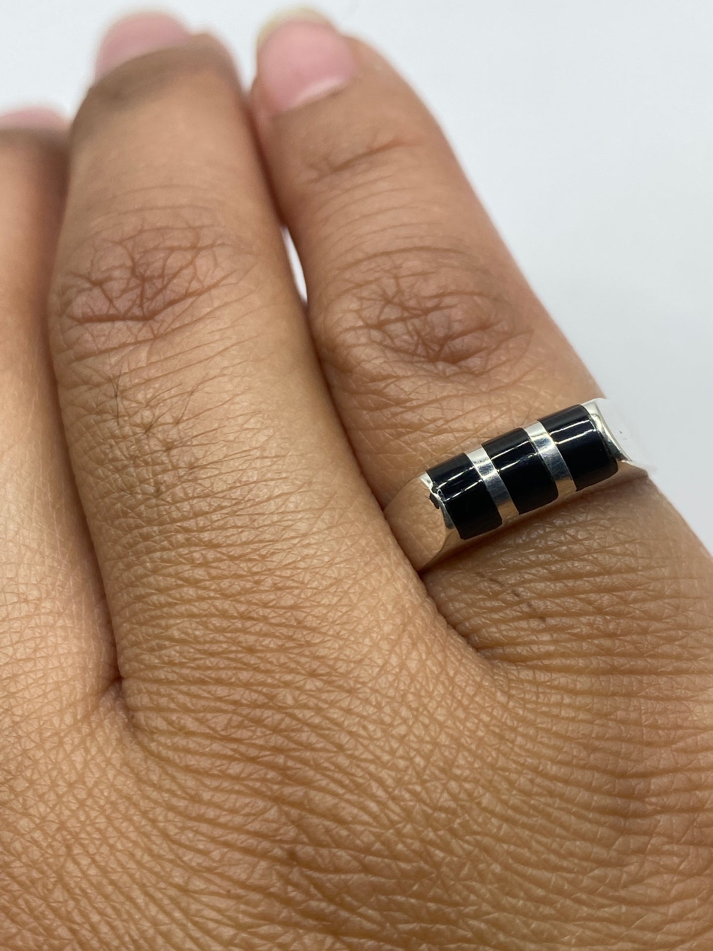 Anillo solitario de ónix negro en dedo, mostrando el sello .925 de autenticidad