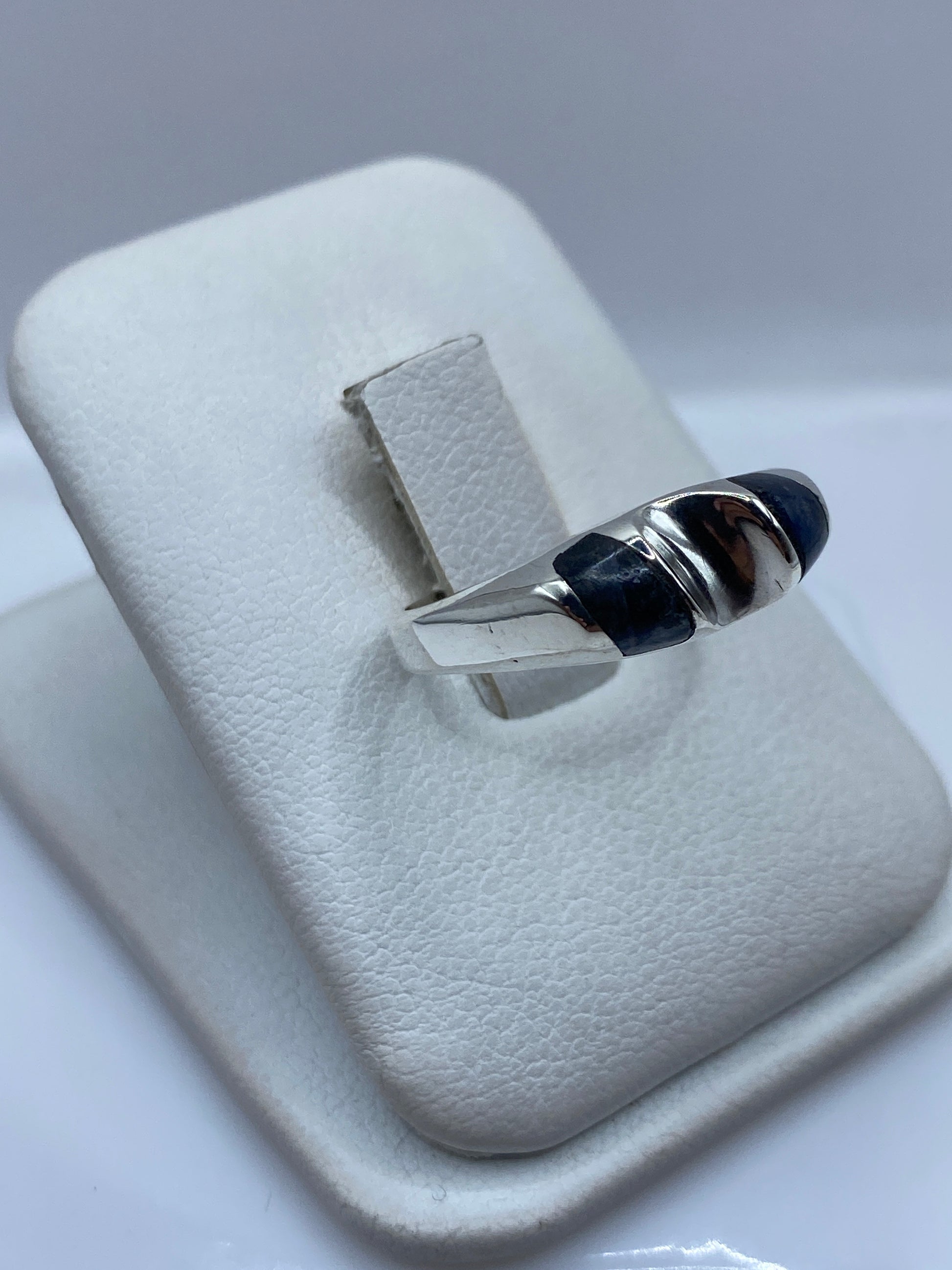 Detalle frontal del anillo mostrando la piedra azul profunda con vetas doradas