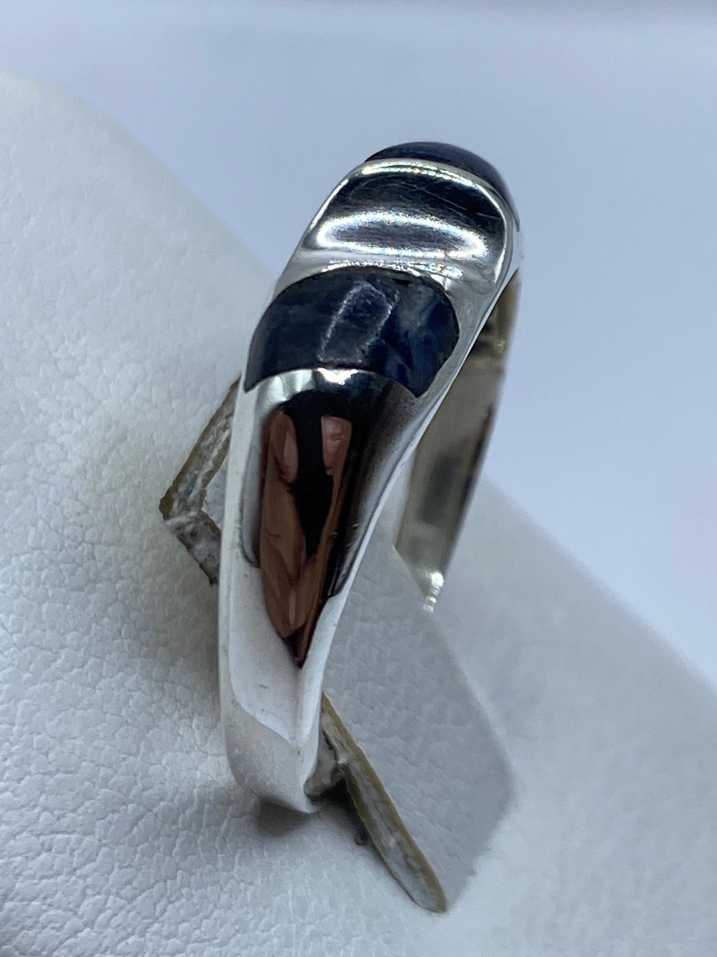 Anillo de plata con lapislázuli puesto en dedo, vista lateral del diseño minimalista