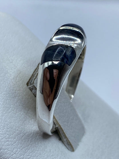 Anillo de plata con lapislázuli puesto en dedo, vista lateral del diseño minimalista