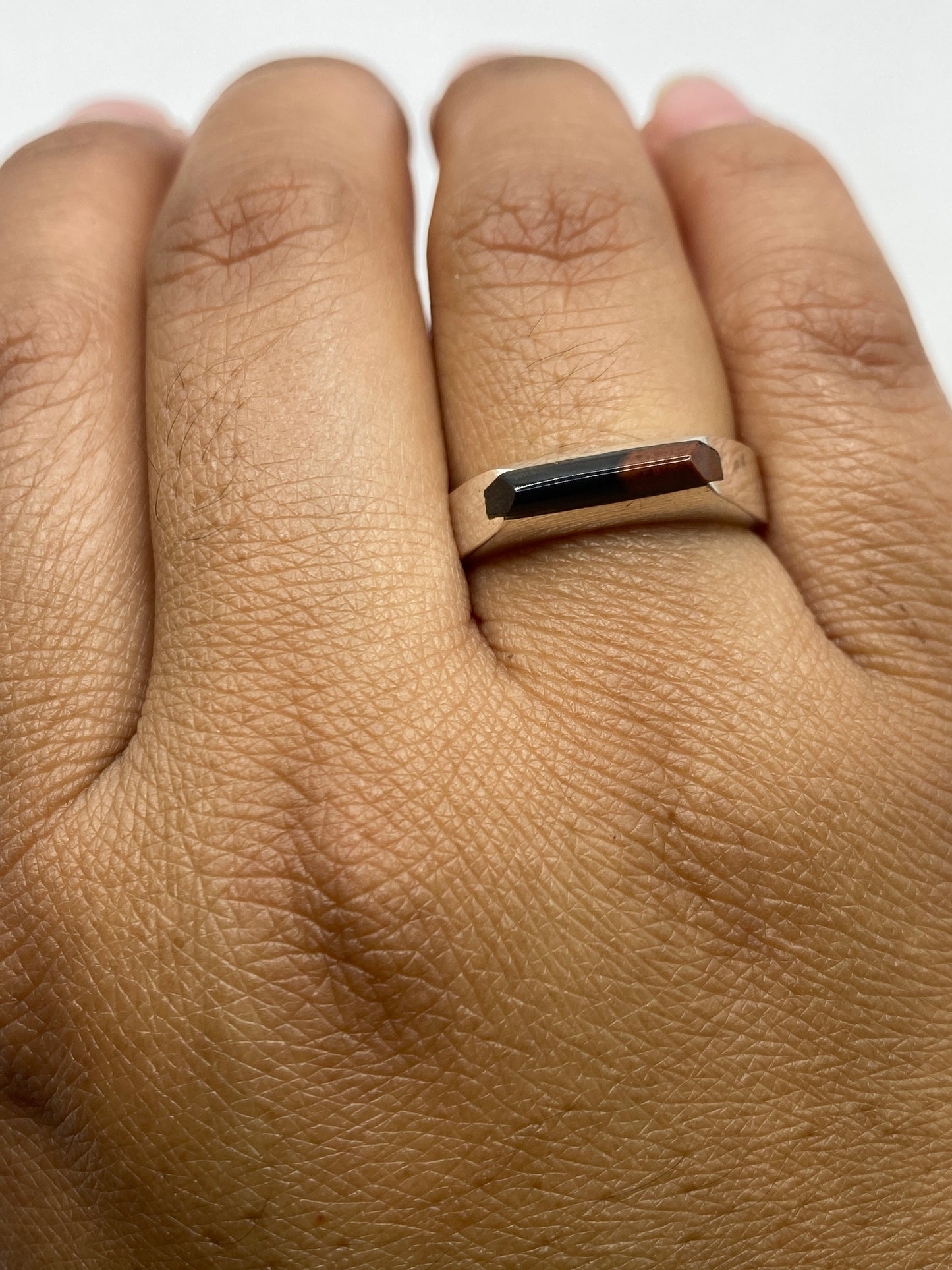 Anillo de ónix y plata sobre fondo gris mostrando la profundidad del negro natural