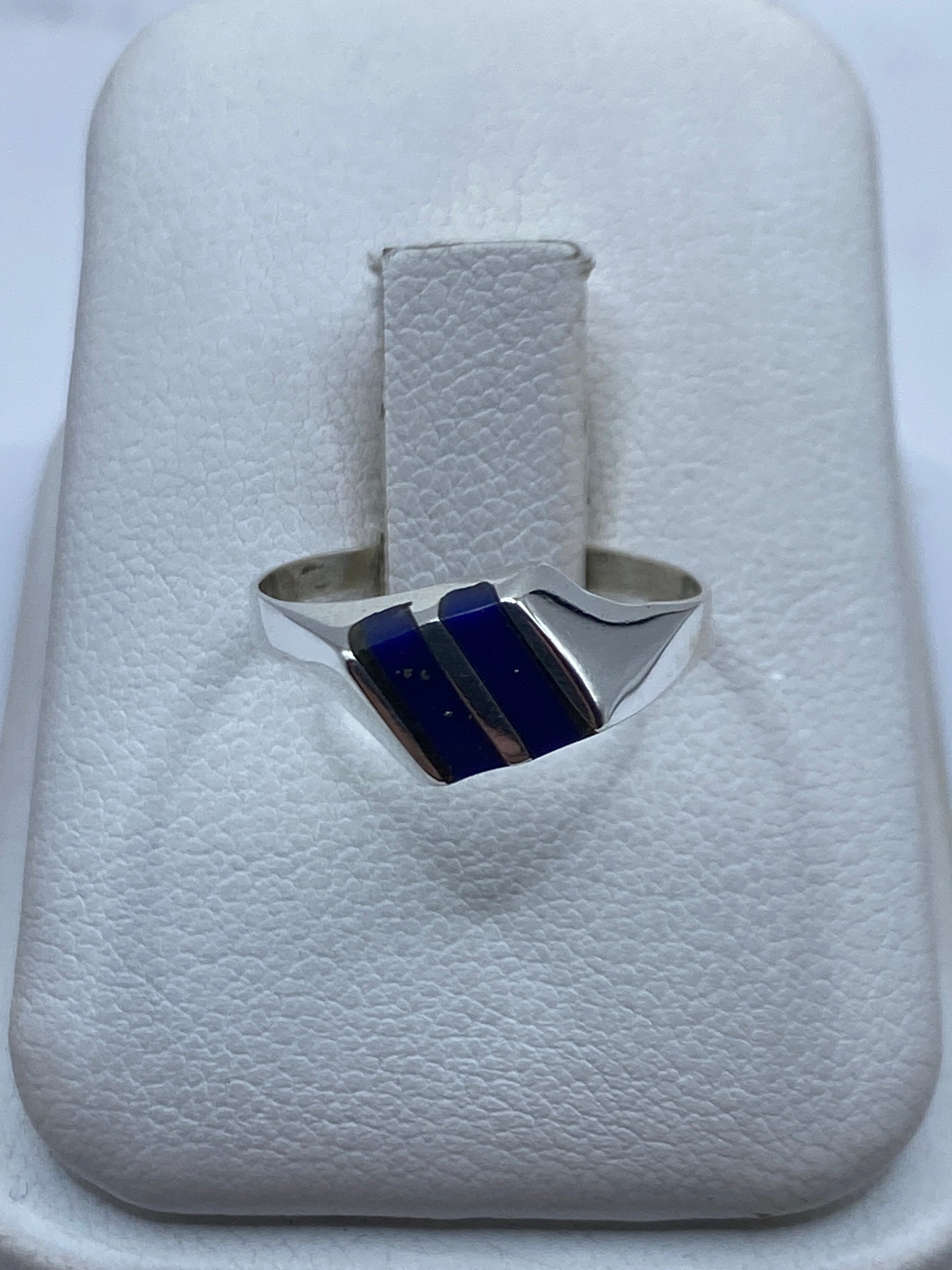 Anillo de plata con piedra azul en presentación sobre estuche blanco