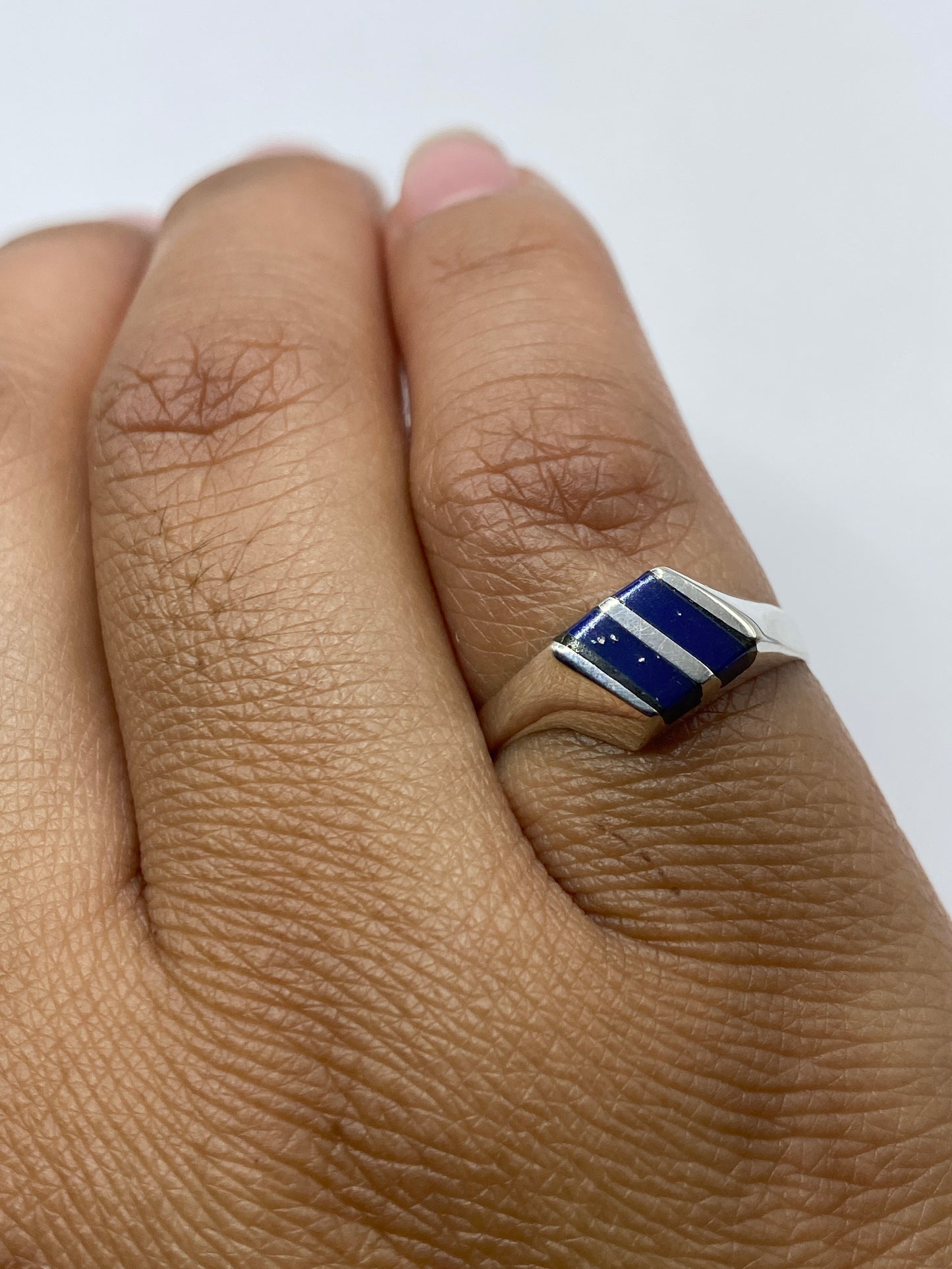 Anillo en dedo mostrando el sello 925 y piedra azul brillante
