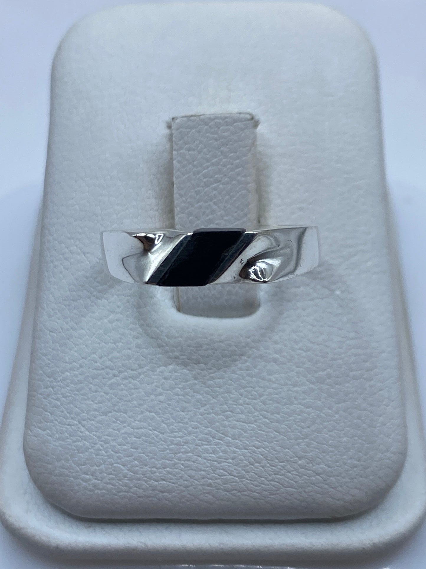 Anillo de plata con ónix negro en diseño asimétrico sobre caja de presentación