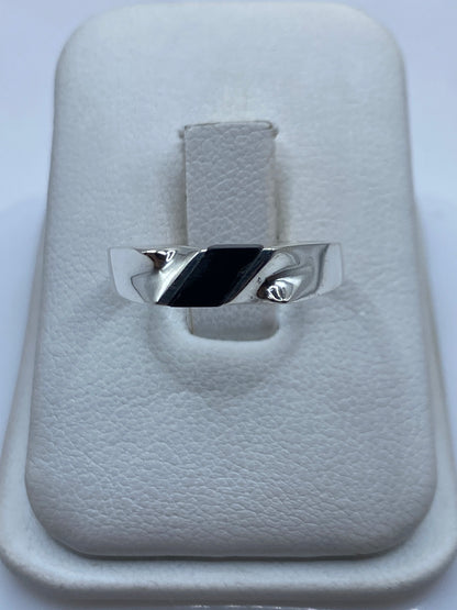 Anillo de plata con ónix negro en diseño asimétrico sobre caja de presentación