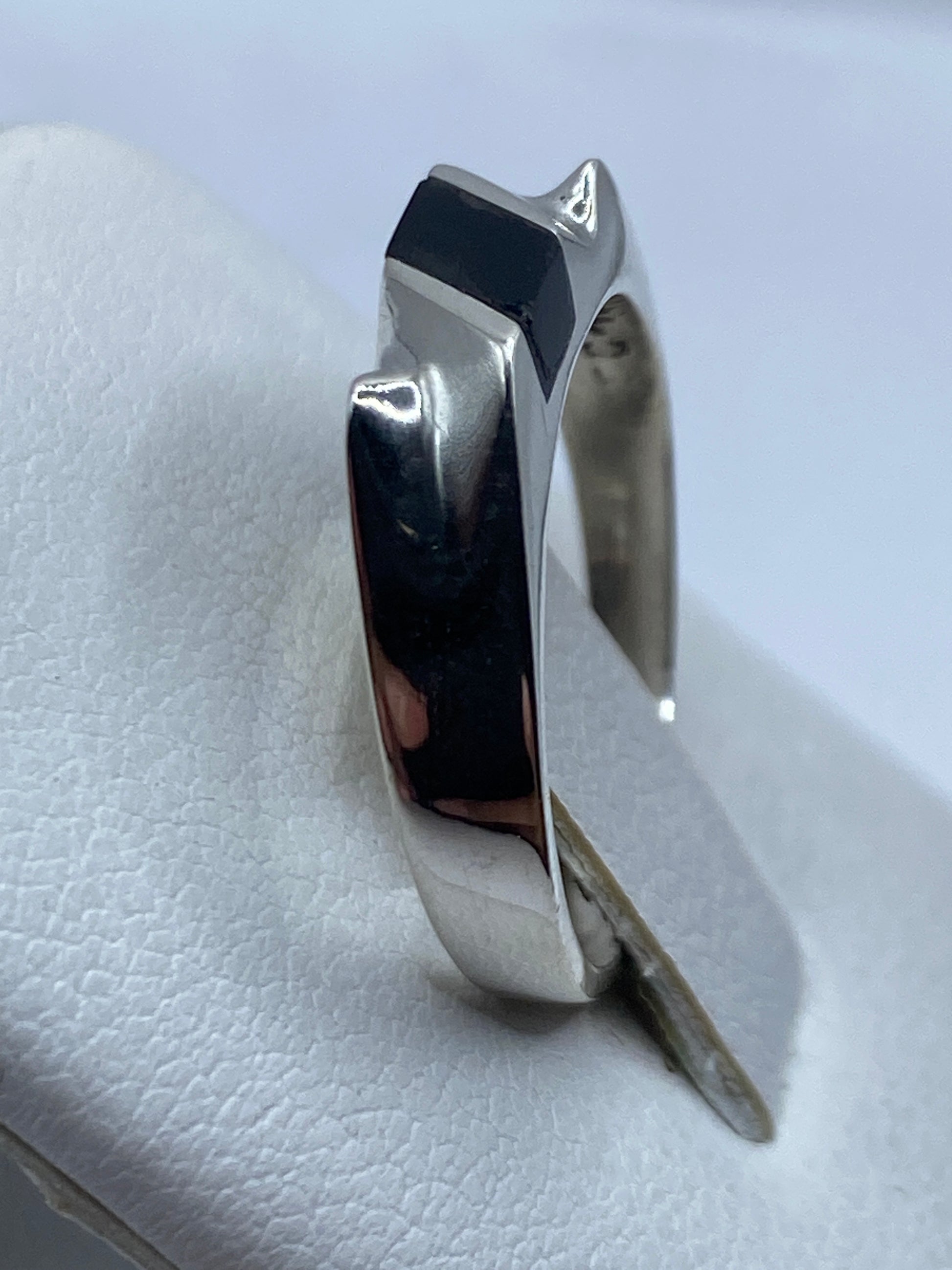Anillo en la mano de una persona, ónix negro brillante con plata pulida