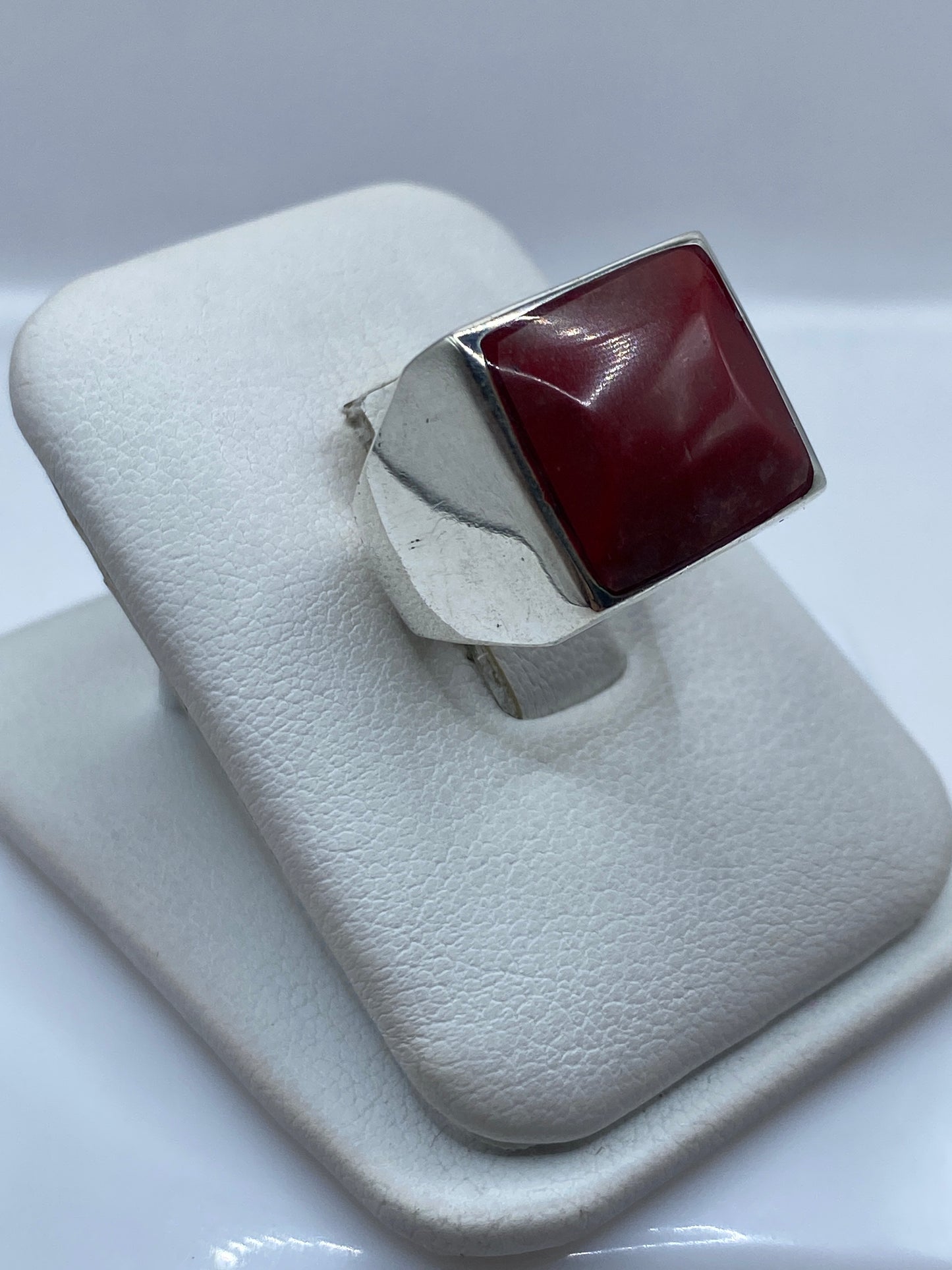 Anillo escultural coral rojo en mano, mostrando el tamaño y presencia real