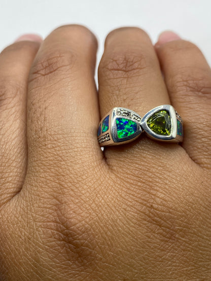Anillo de plata en mano de mujer, ópalo azul brillante con reflejos verdes, sello .925 visible