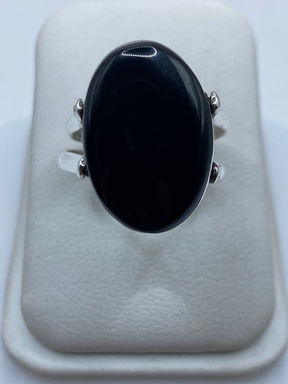 Anillo de plata .925 con ónix negro pulido en dedo de mujer