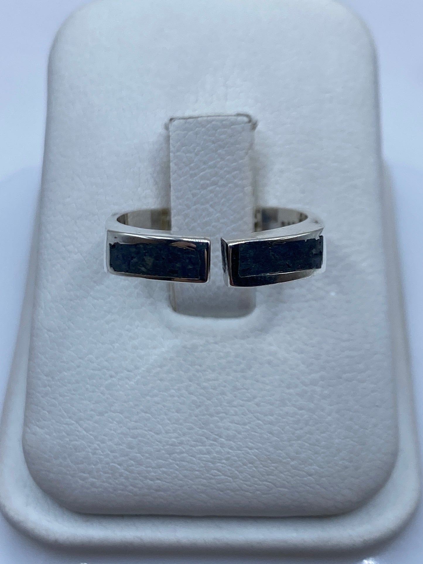 Anillo de plata ajustable con incrustación contrastante en el dedo de una mujer