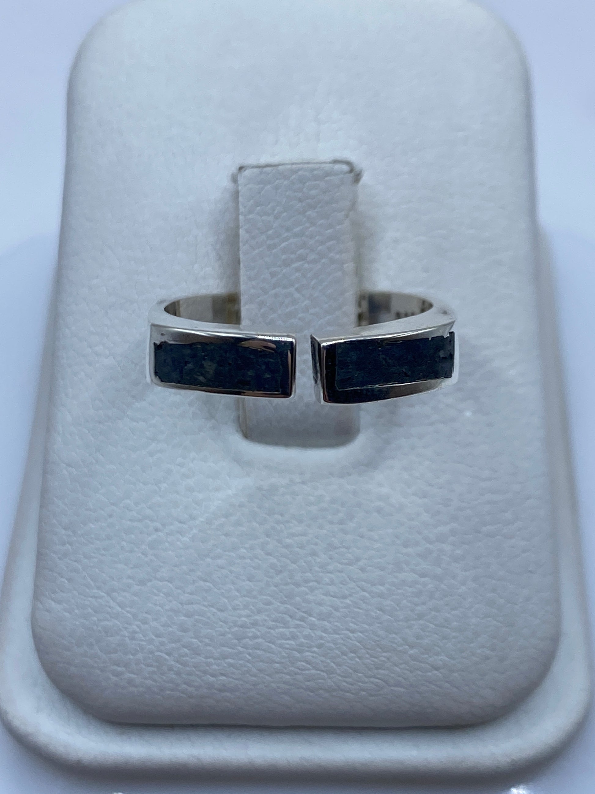 Anillo de plata ajustable con incrustación contrastante en el dedo de una mujer