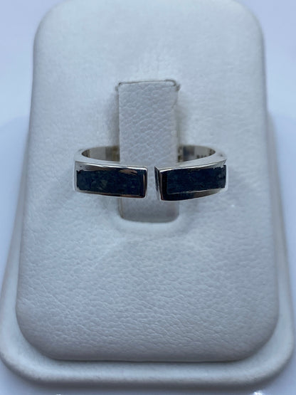 Anillo de plata ajustable con incrustación contrastante en el dedo de una mujer