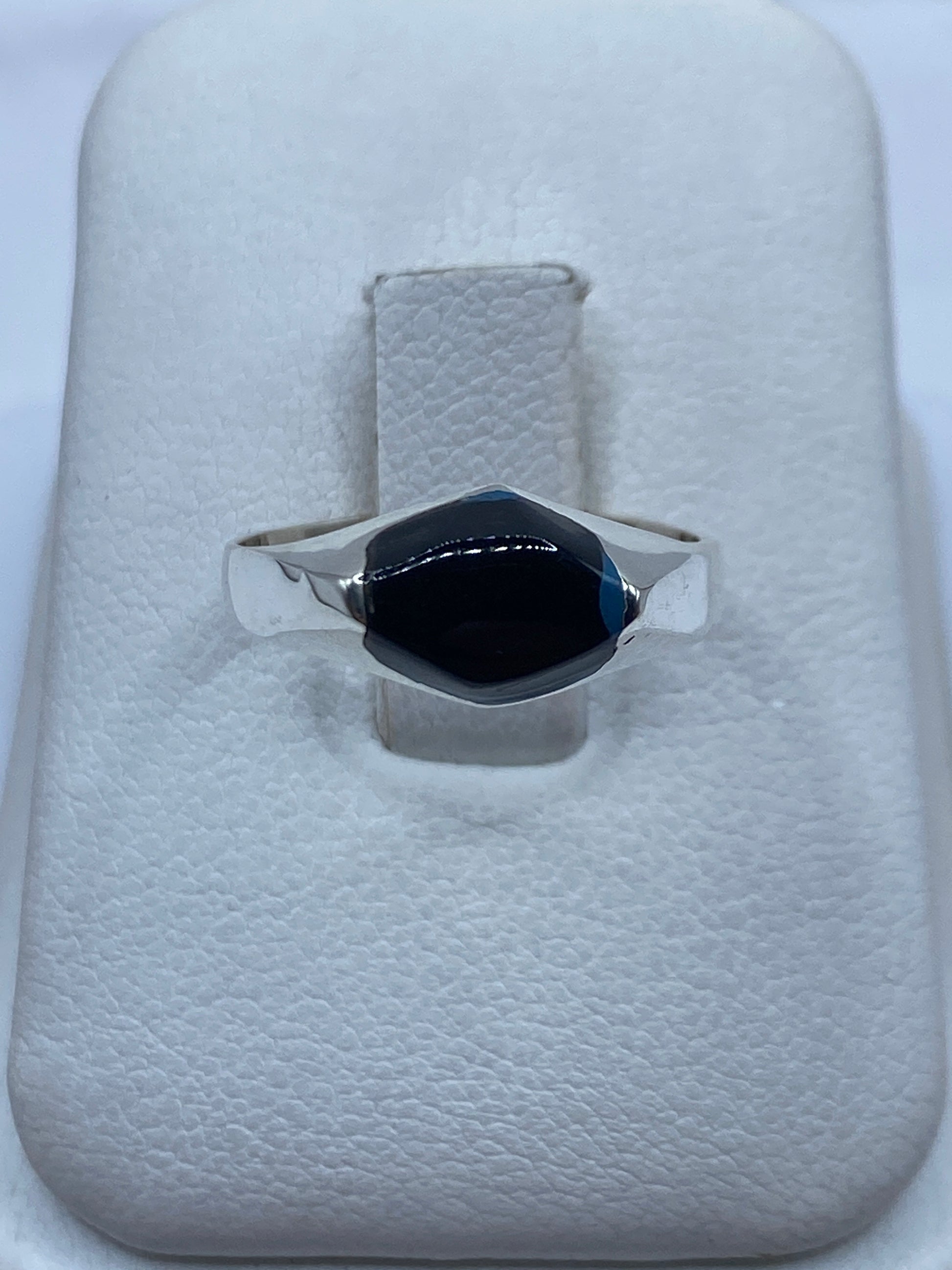 Anillo de plata con ónix negro solitario sobre estuche blanco