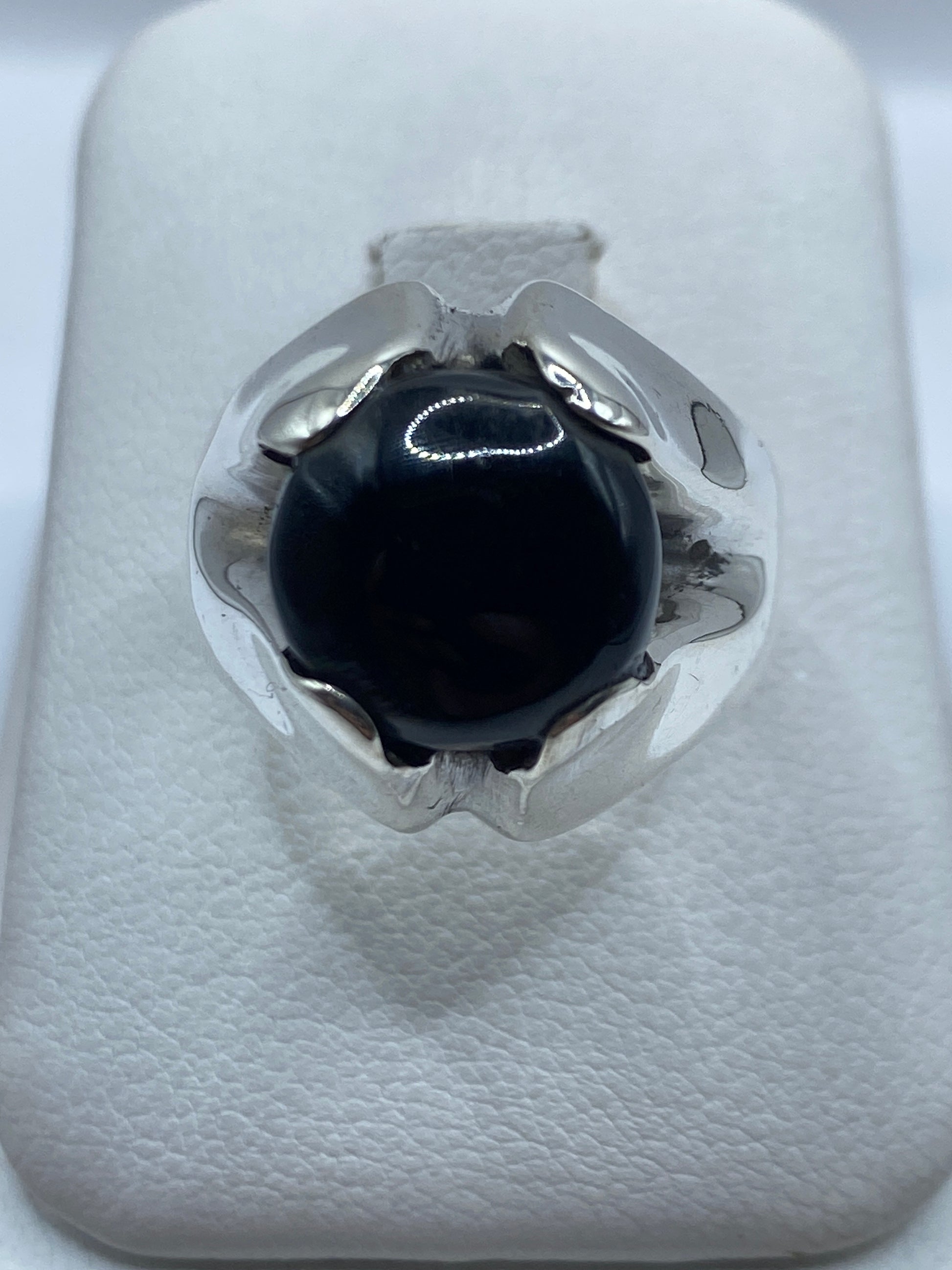 Anillo masivo de plata con ónix negro pulido visto desde arriba en estuche blanco