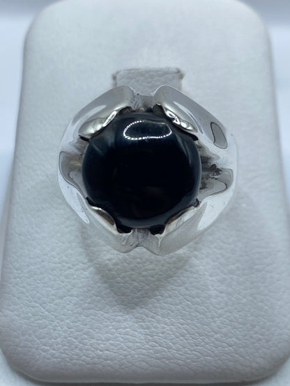 Anillo masivo de plata con ónix negro pulido visto desde arriba en estuche blanco