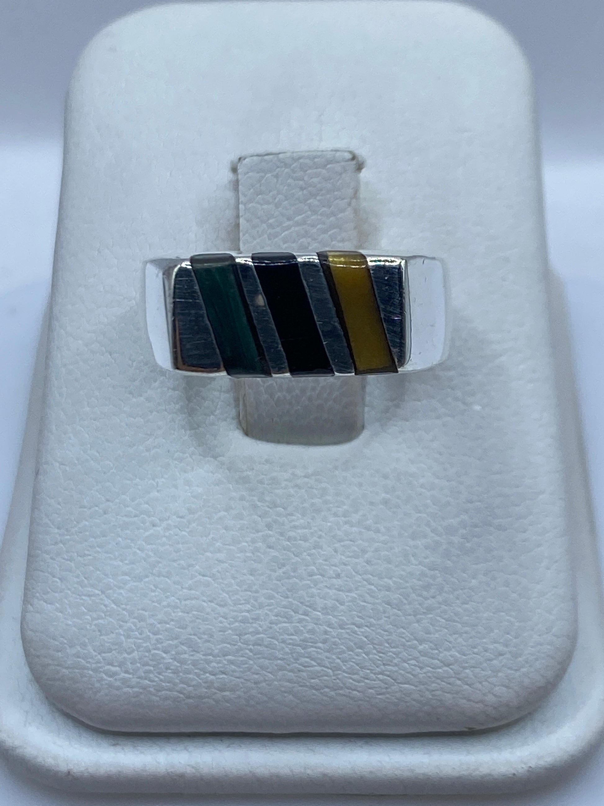 Anillo de plata .925 con malaquita verde natural en la mano, veteado blanco y negro visible