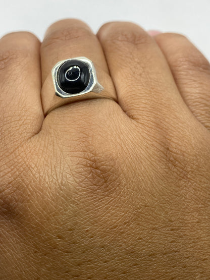 Anillo con sello de ónix sobre fondo gris, mostrando peso y presencia