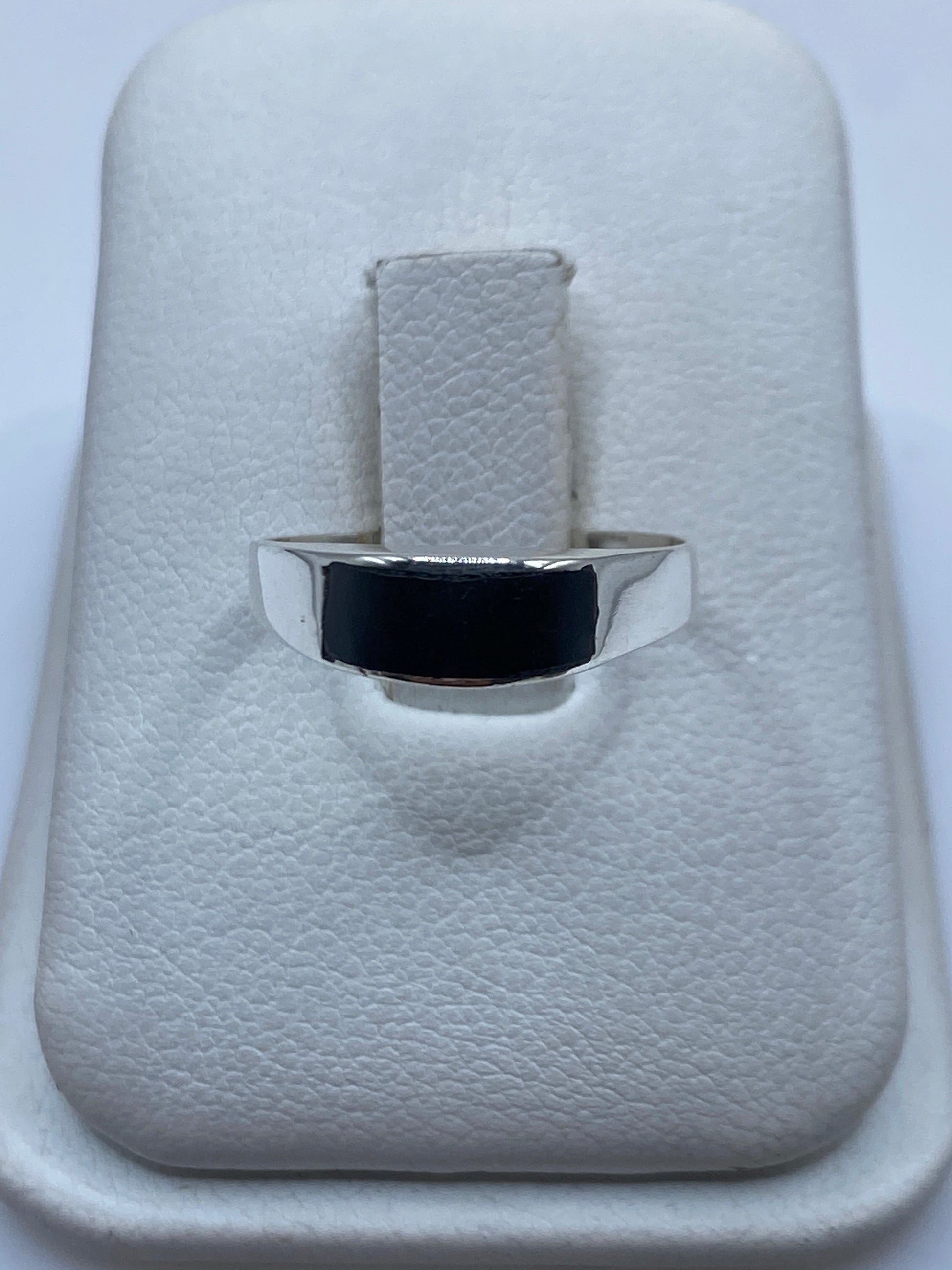 Anillo de plata con ónix negro pulido sobre estuche blanco