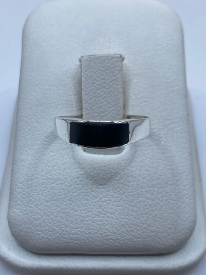 Anillo de plata con ónix negro pulido sobre estuche blanco