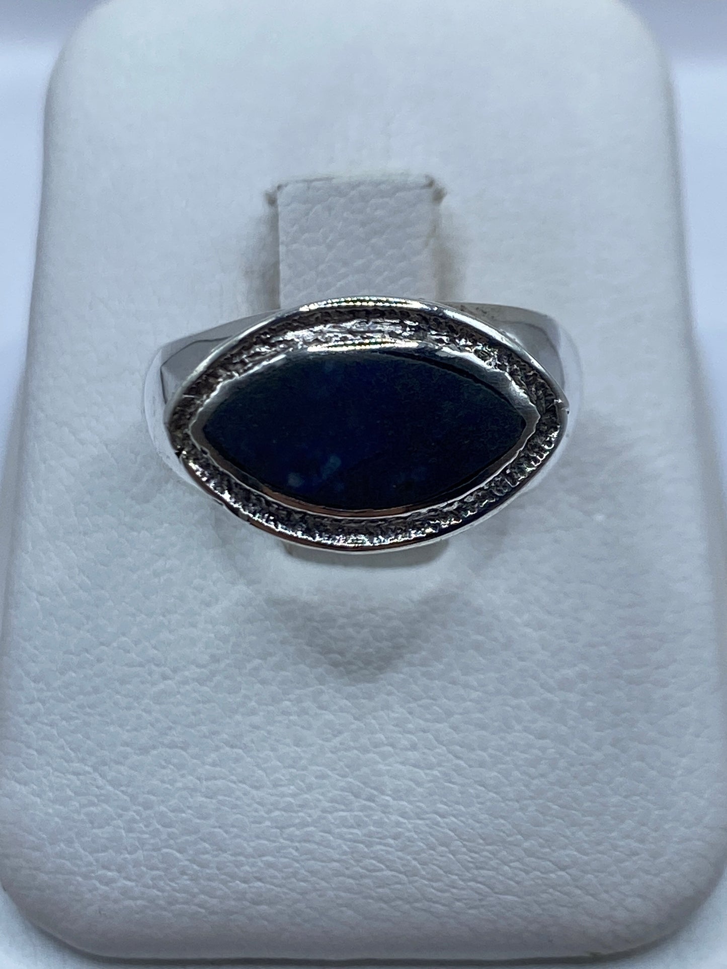 Anillo de plata con lapislázuli azul profundo, frente oval con marco ornamental labrado
