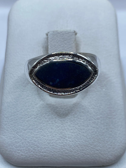 Anillo de plata con lapislázuli azul profundo, frente oval con marco ornamental labrado