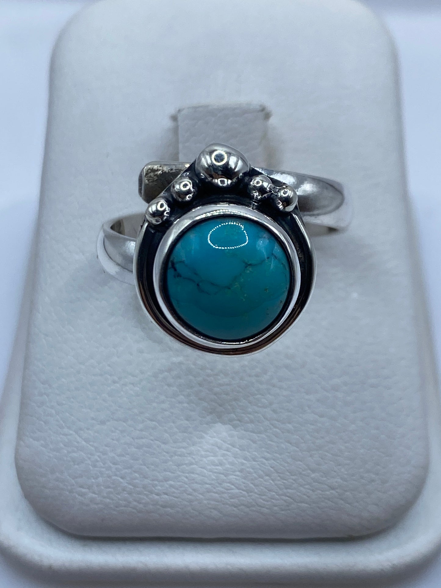 Anillo de turquesa azul cielo con esferas de plata .925 en la mano de una mujer