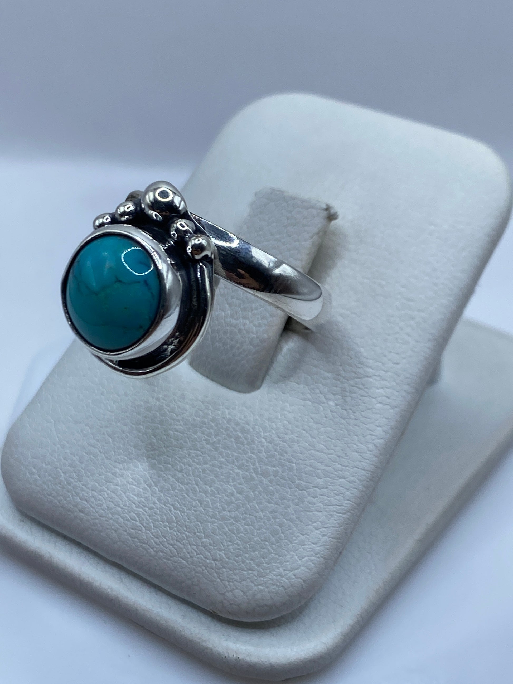 Vista lateral del anillo ajustable de turquesa natural con montura de plata